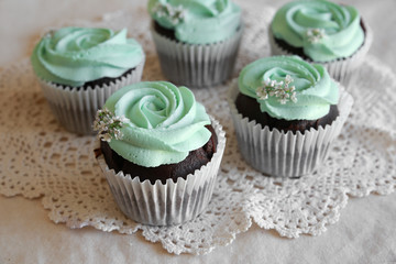 Homemade chocolate cupcake with turquoise rose frosting