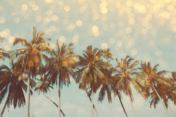 Palm trees on tropical shore with golden party glamour bokeh overlay, double exposure effect stylized