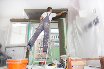 Plasterer renovating indoor walls and ceilings.