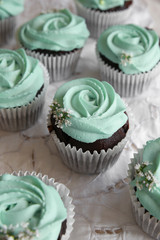 Homemade chocolate cupcake with turquoise rose frosting