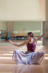 classic ballet dancer posing at barre on rehearsal room