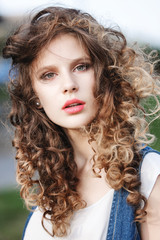 Fototapeta premium close-up portrait of a beautiful young girl with curly brown hai
