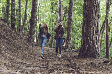 Fototapeta premium Twin sister walking on forest trail. Walking towards camera.