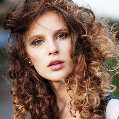 Portrait of a beautiful young girl with long curly hair