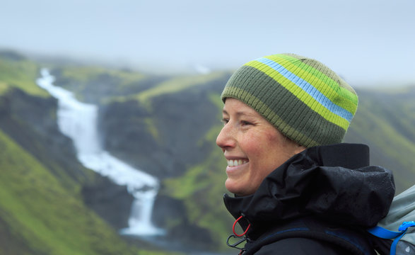 Happy, young woman at the Ofaerufoss waterfall in the Eldgja canyon, Iceland