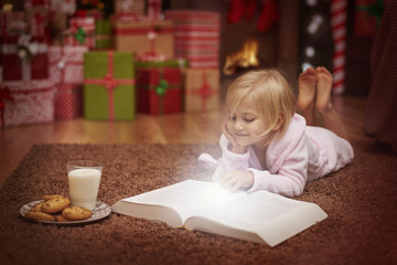 Little girl reading book about amazing adventures
