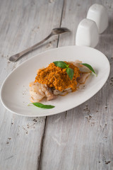 Cod with sauce Romanesco on the oval ceramic plate