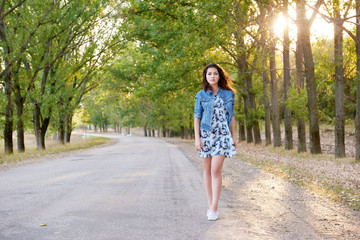 girl walking on a countryside road at sunset