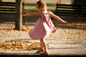 Full length portrait of a little girl dancing in the park a warm - Powered by Adobe