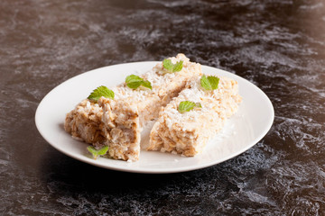 oat bar with coconut with mint on a plate, close up, horizontal