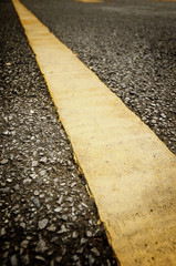 Fototapeta premium Single Yellow line marking on road surface for separation between traffic moving in opposite directions.
