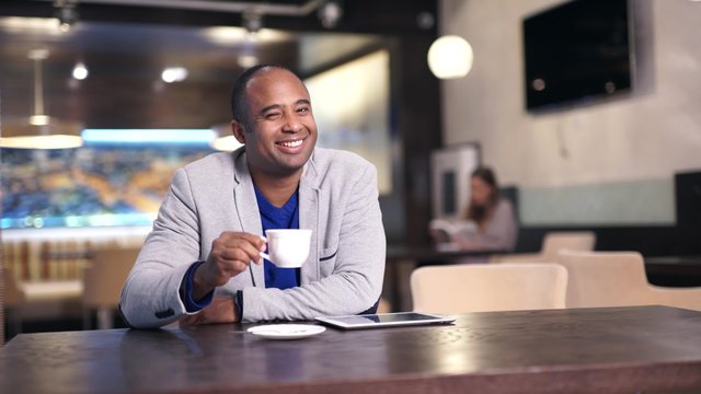 Happy man drinking coffee and smiling