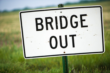 Bridge Out Sign With Bullet Holes and Green Pasture