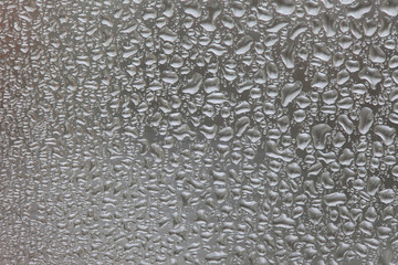 The texture of dew drops on a dark glass