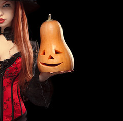 Girl with Halloween pumpkin on black background