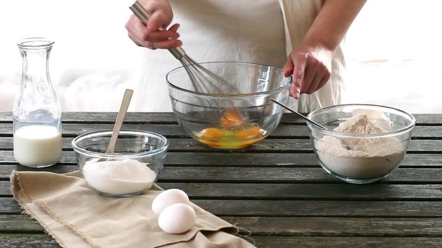 Woman mixes ingredients for sponge cake. Rustic style.