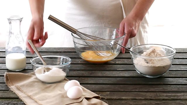 Woman mixes ingredients for sponge cake. Rustic style.