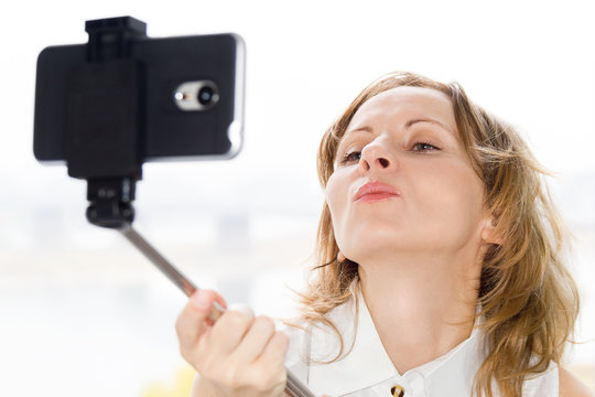 Beautiful woman doing selfie through selfie stick