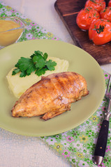 Grilled chicken fillet with mashed potatoes and grilled tomatoes. Rustic style.