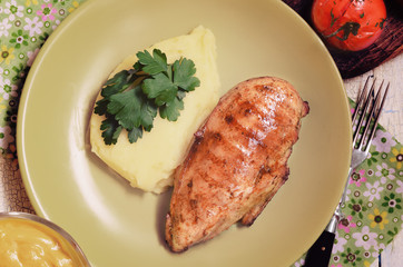 Grilled chicken fillet with mashed potatoes and grilled tomatoes. Rustic style.