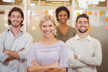 Fototapeta premium Portrait of smiling business team with arms crossed in office