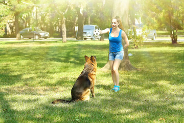 Beautiful young girl with dog in park