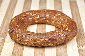 Crispy Italian bagel made of rye flour and sunflower seeds. Studio shot on wooden table.
