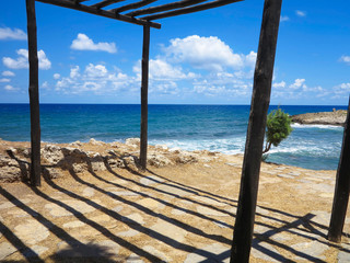 Old wooden canopy on the sea coast and blue sky