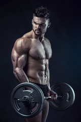 Muscular bodybuilder guy doing exercises with big dumbbell