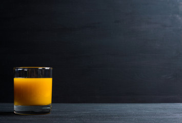 Fresh made peach juice on black wooden background