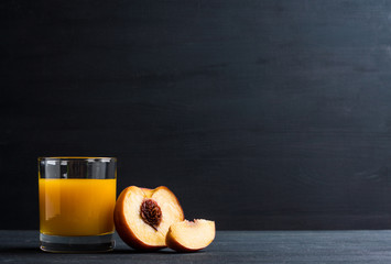 Fresh made peach juice on black wooden background © maxandrew