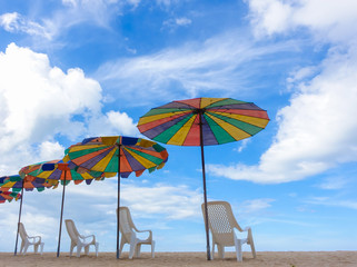 Beach chairs with colorful umbrella at the beach with blue-sky background on summer.