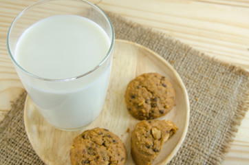 milk and cookie on wooden board background