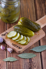 Pickles in bank with garlic and pepper on a table