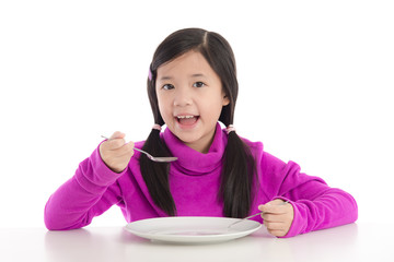 Beautiful asian girl holding a spoon and fork