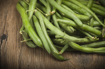 Group of green beans on the wood.