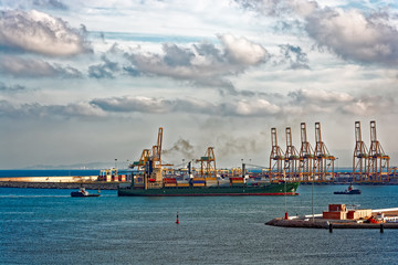 Fototapeta premium Tugboats assisting container ship
