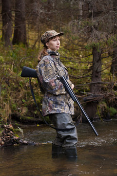 Woman hunter with gun looking into the distance