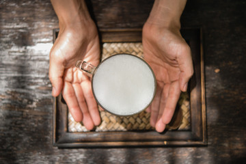 Woman holding a glass of hot milk relax in the cafe.