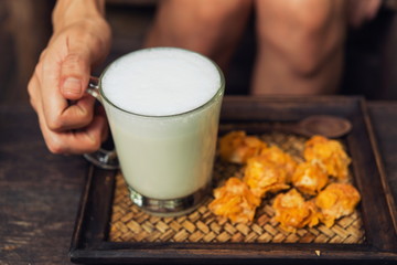 Woman holding a glass of hot milk relax in the cafe.