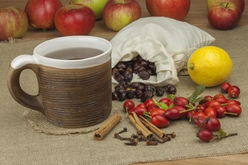 A flu epidemic. Traditional home treatment for colds and flu. Rosehip tea, honey and citrus. Hot tea with honey and lemon on a tabletop. Home Pharmacy. Proven treatment of diseases.
