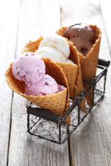 Waffle cones with ice cream on wooden table