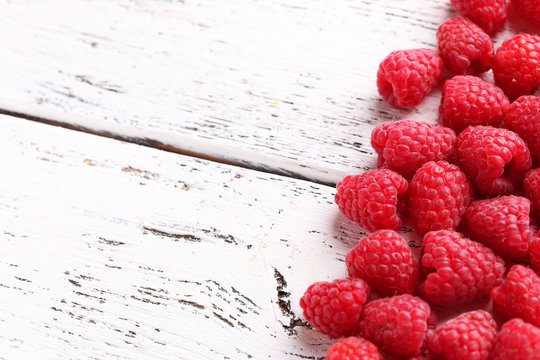 Red raspberries on white wooden background