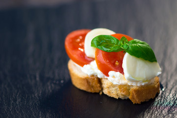 Delicious slice of bread with buffalo mozzarella, tomatoes and fresh basil