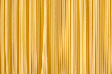 Background made of raw pasta stacked vertically