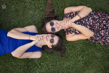 Naklejka premium Two intimate cute girls, relaxing in grass. Made 