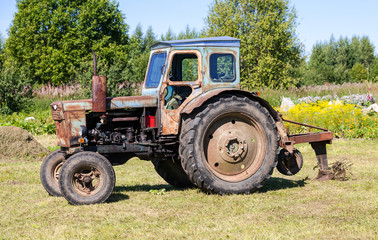 Obraz premium Old tractor at the russian village in sunny day