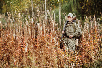 man hunter with shotgun in forest