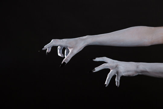 Scary pale Halloween hands with black nails