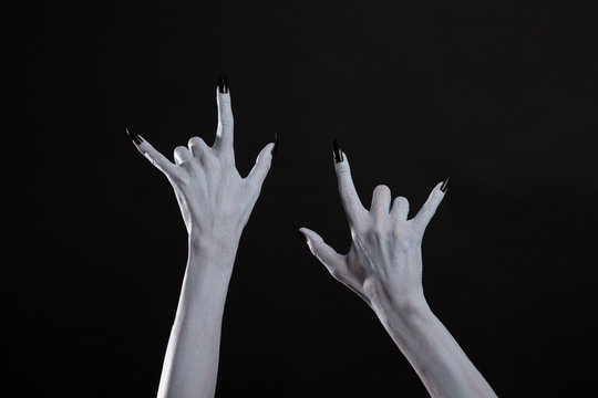Pale monster hands showing heavy metal symbol